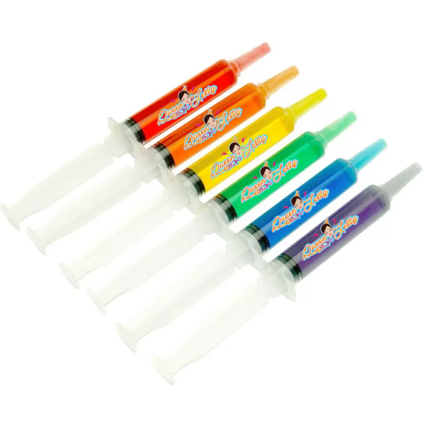 The image shows six colorful jello shot syringes arranged in a diagonal row. Each syringe contains a different color of liquid—red, orange, yellow, green, blue, and purple—and they all have the "Queen Jelly" logo prominently displayed on the side. The syringes are transparent with white plungers and tips